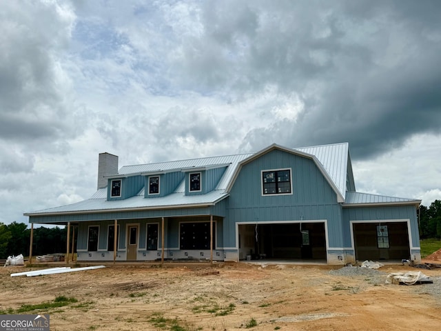 1237 Morgan Rd, Bremen, GA 30110 - back of house with a metal roof, a chimney, covered porch, a garage, and board and batten siding