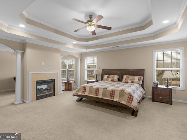 bedroom with decorative columns, a raised ceiling, and arched walkways