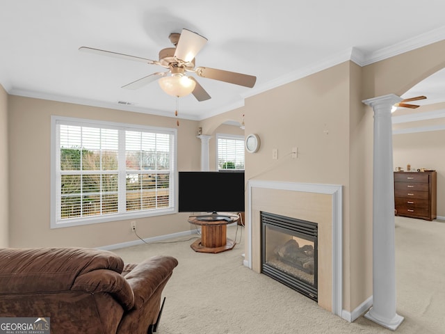 living area featuring arched walkways, carpet flooring, and ornate columns