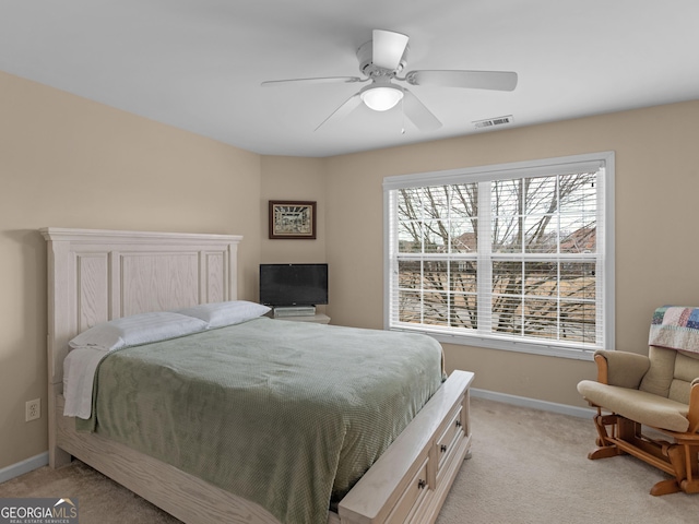 bedroom with a ceiling fan, baseboards, visible vents, and light carpet