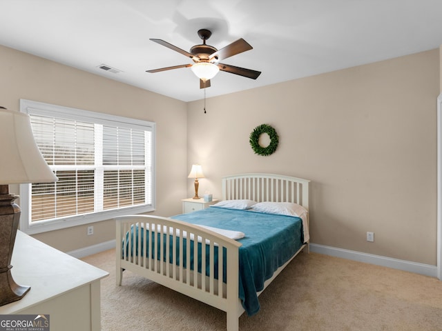 bedroom featuring ceiling fan, baseboards, visible vents, and light carpet