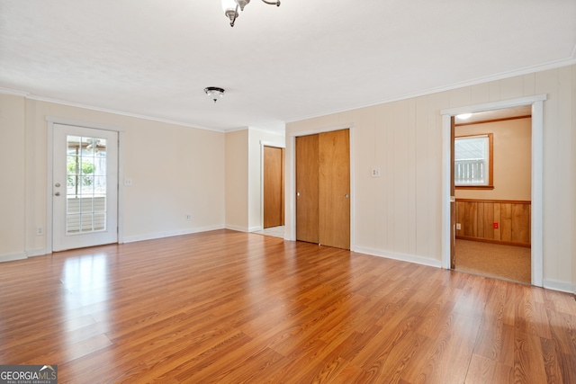 interior space with light wood finished floors, baseboards, and crown molding