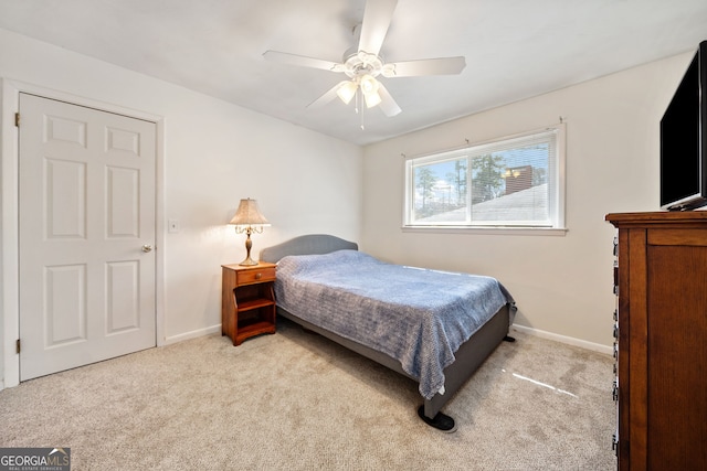 bedroom featuring a ceiling fan, light colored carpet, and baseboards