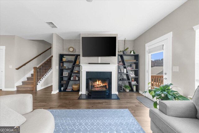 2401 Cotton Gin Row, Jefferson, GA 30549 - living area with baseboards, wood finished floors, a warm lit fireplace, and stairway
