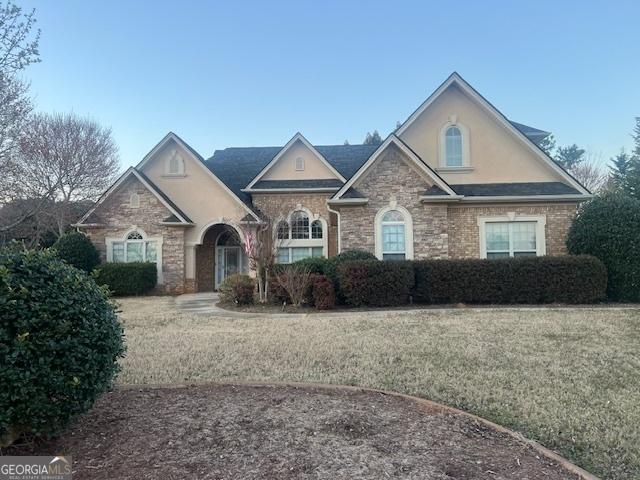 view of front facade with stucco siding and a front lawn