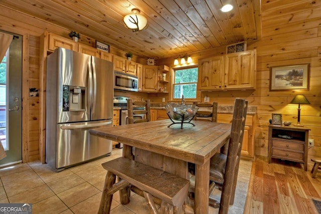 kitchen featuring stainless steel appliances, wood ceiling, light brown cabinets, and wood walls