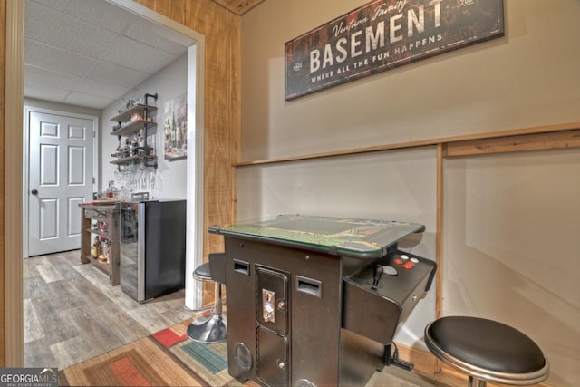 interior space featuring a dry bar, wood finished floors, and a paneled ceiling