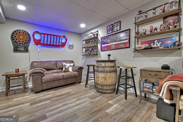 bar featuring baseboards, a drop ceiling, and wood finished floors