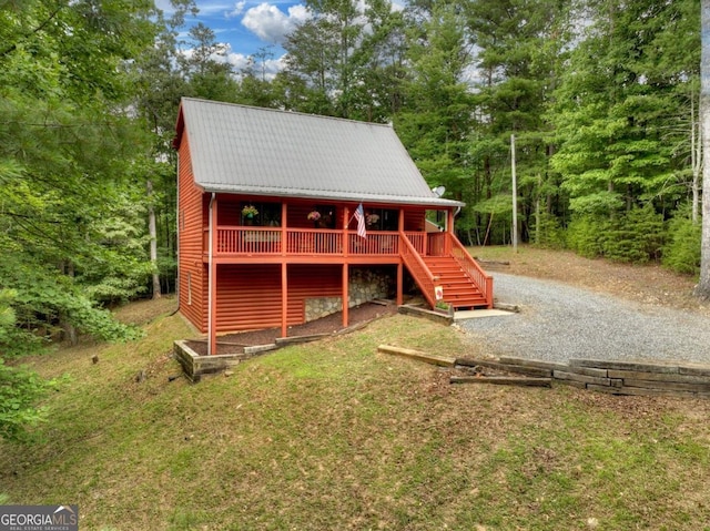 view of outbuilding with gravel driveway and stairs