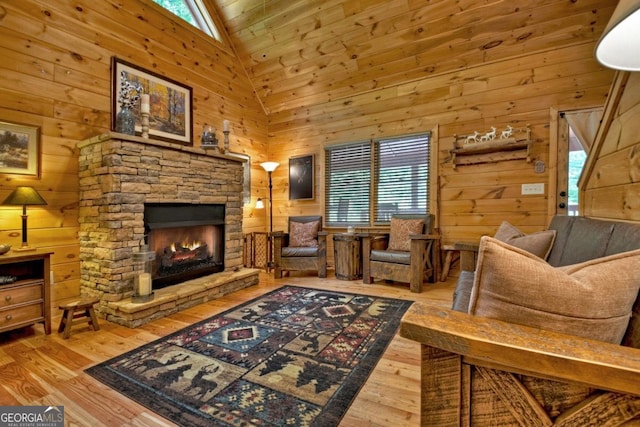 sitting room with a fireplace, plenty of natural light, and wooden walls