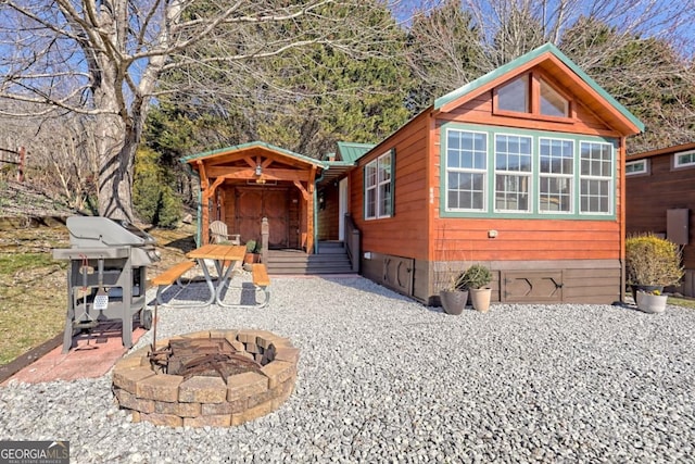 view of front of property featuring metal roof and a fire pit