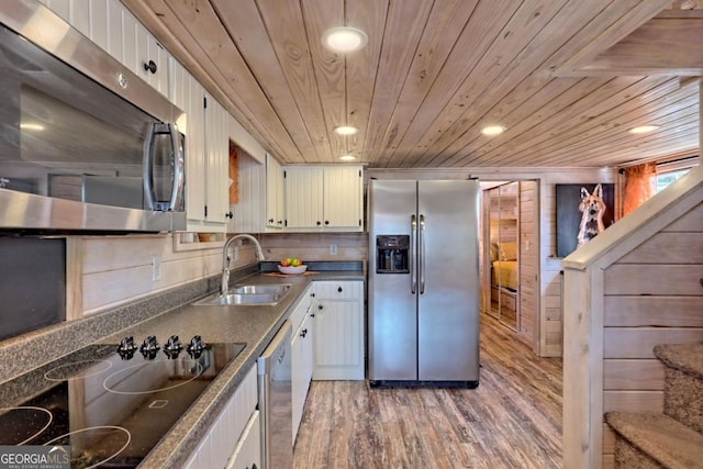 664 River Vista Dr, Dillard, GA 30537 - kitchen with stainless steel appliances, wooden ceiling, light wood finished floors, dark countertops, and white cabinetry