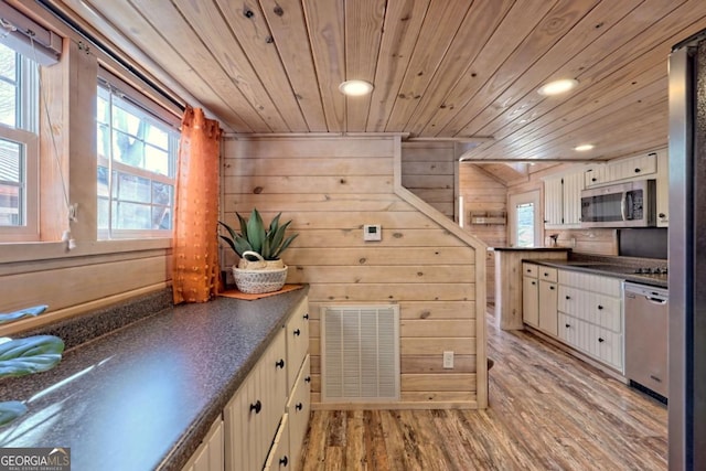 664 River Vista Dr, Dillard, GA 30537 - kitchen featuring appliances with stainless steel finishes, dark countertops, wooden ceiling, recessed lighting, and wood walls