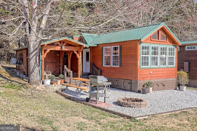 664 River Vista Dr, Dillard, GA 30537 - view of front facade with a fire pit, a metal roof, a front lawn, and a patio