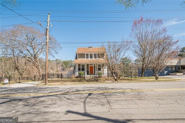 view of front facade featuring covered porch and a fenced front yard