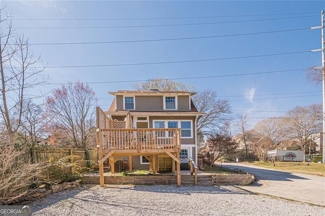 view of front of home featuring stairway, fence, and a wooden deck