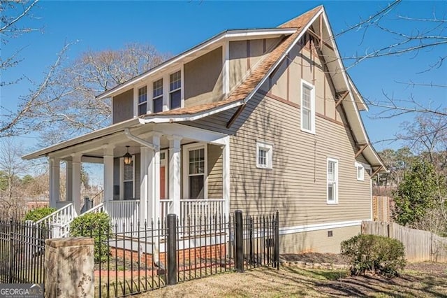 view of front facade with a porch, crawl space, and a fenced front yard