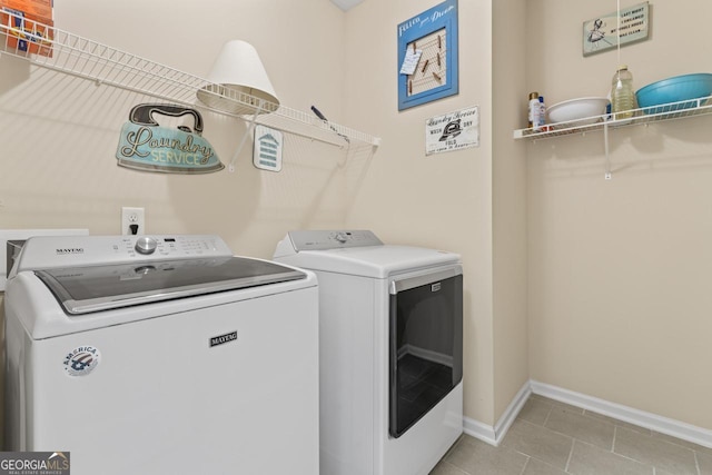 laundry area featuring laundry area, light tile patterned floors, baseboards, and separate washer and dryer