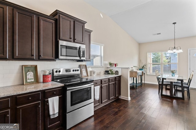 kitchen featuring dark wood-style floors, vaulted ceiling, stainless steel appliances, dark brown cabinets, and backsplash