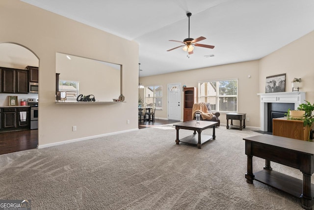 living room featuring carpet, a fireplace with flush hearth, visible vents, and baseboards