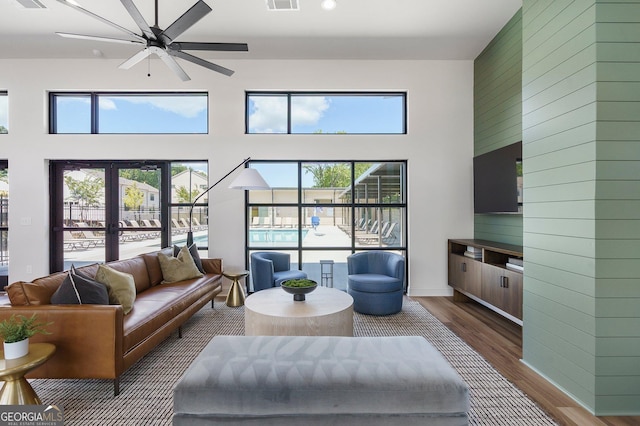 living area featuring a towering ceiling, dark wood finished floors, and visible vents