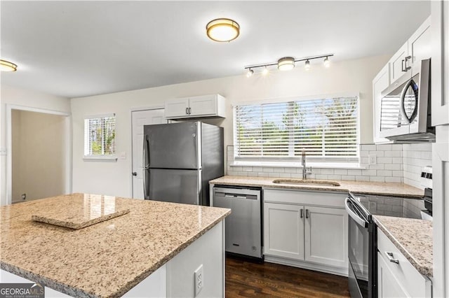 kitchen with stainless steel appliances, backsplash, plenty of natural light, and a sink