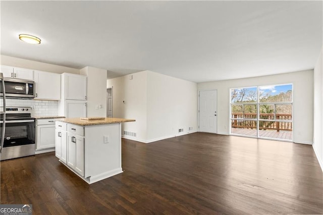 kitchen featuring a center island, visible vents, backsplash, appliances with stainless steel finishes, and open floor plan