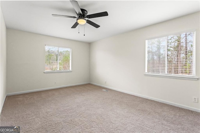 spare room with carpet, baseboards, and a ceiling fan