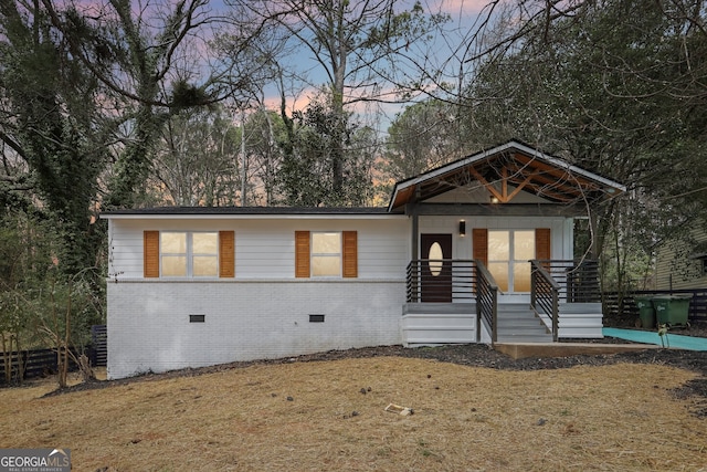 view of front of home featuring crawl space, fence, and brick siding