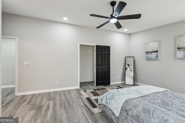 bedroom with baseboards, wood finished floors, and recessed lighting