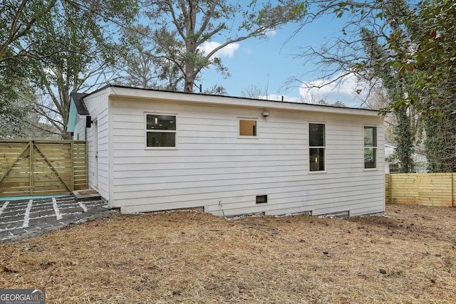 back of property with crawl space and fence