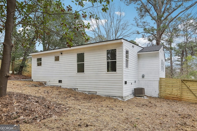 view of home's exterior featuring central AC unit and fence