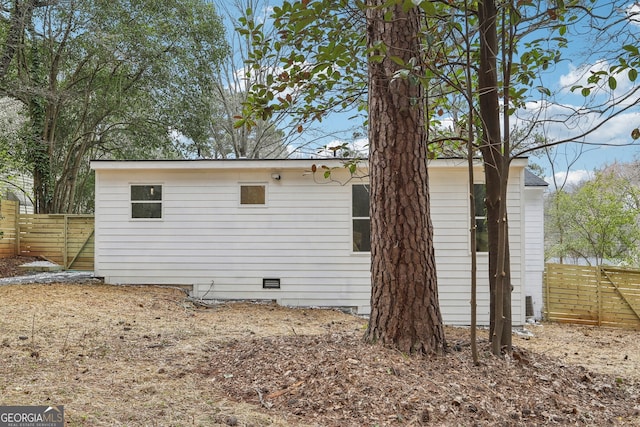 back of house featuring crawl space and fence