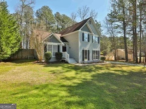 view of front of house with fence and a front lawn