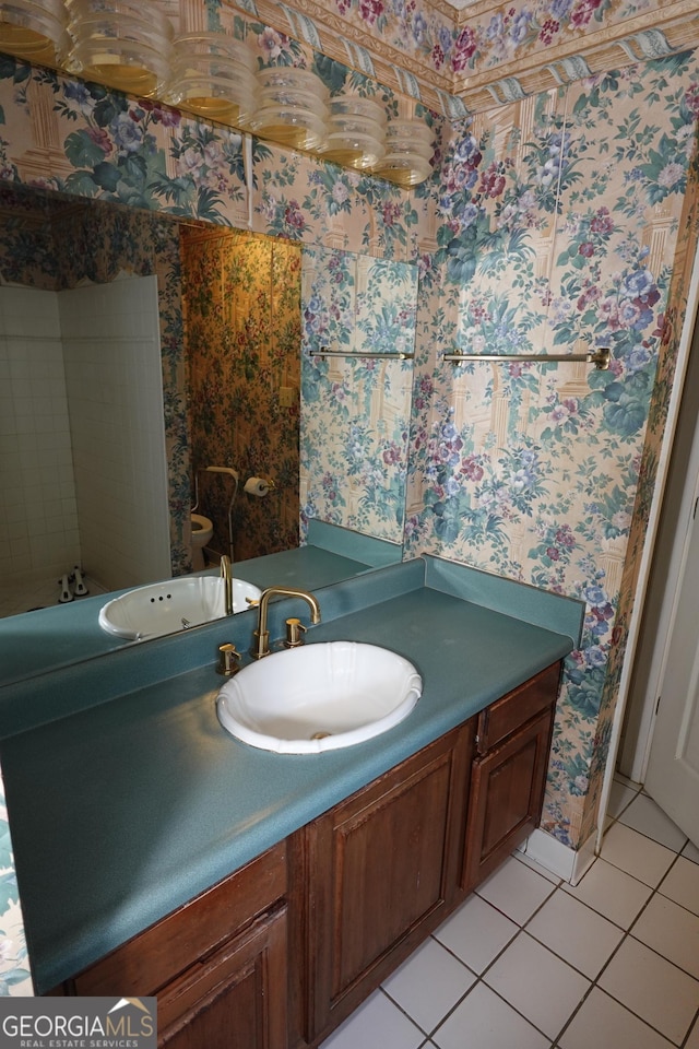 bathroom with tile patterned flooring, vanity, and wallpapered walls