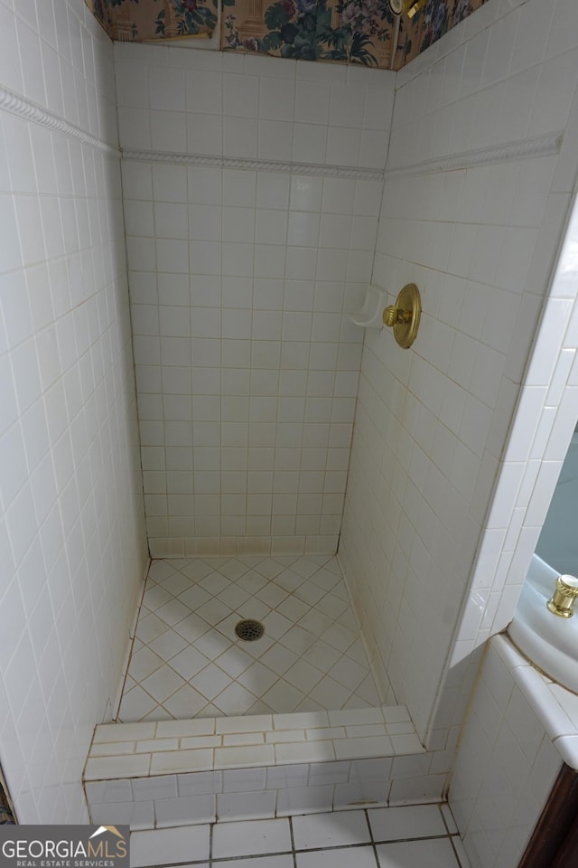 bathroom with a tile shower and tile patterned floors