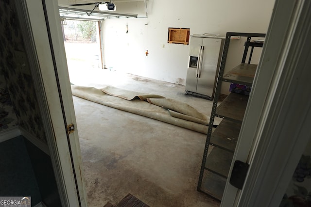 interior space with stainless steel refrigerator with ice dispenser and a garage door opener