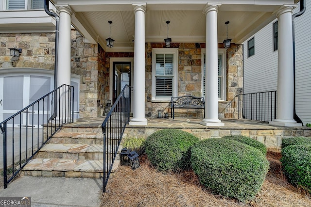 view of exterior entry featuring a porch and stone siding