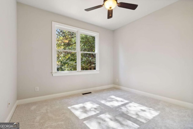 unfurnished room with carpet flooring, visible vents, and baseboards