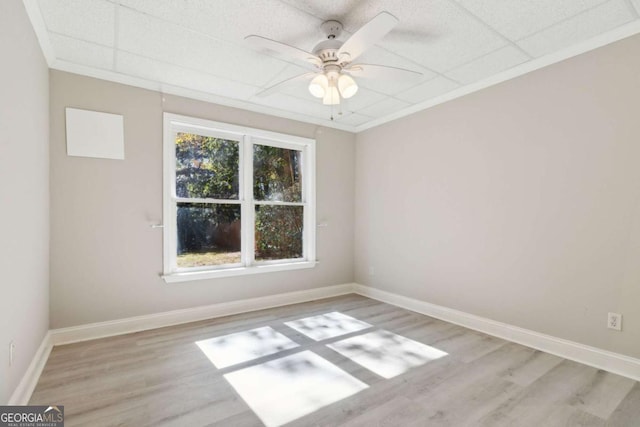 spare room with a ceiling fan, crown molding, baseboards, and wood finished floors