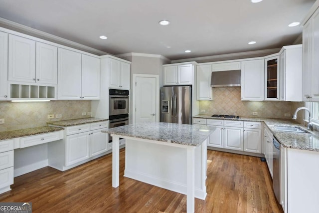 kitchen featuring under cabinet range hood, a sink, white cabinetry, ornamental molding, and appliances with stainless steel finishes