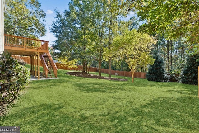 view of yard with stairway, fence, and a deck