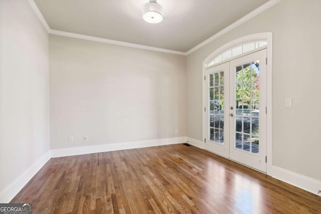 spare room featuring baseboards, french doors, wood finished floors, and crown molding