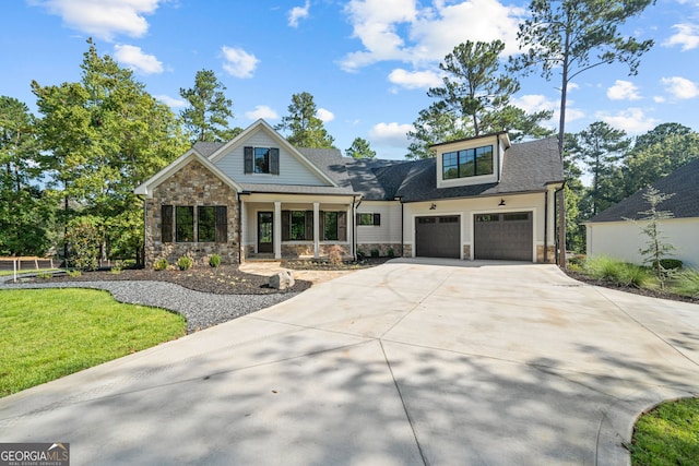 view of front facade with driveway, a garage, a shingled roof, stone siding, and a front yard