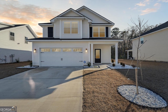 view of front of house with driveway, covered porch, a garage, and board and batten siding