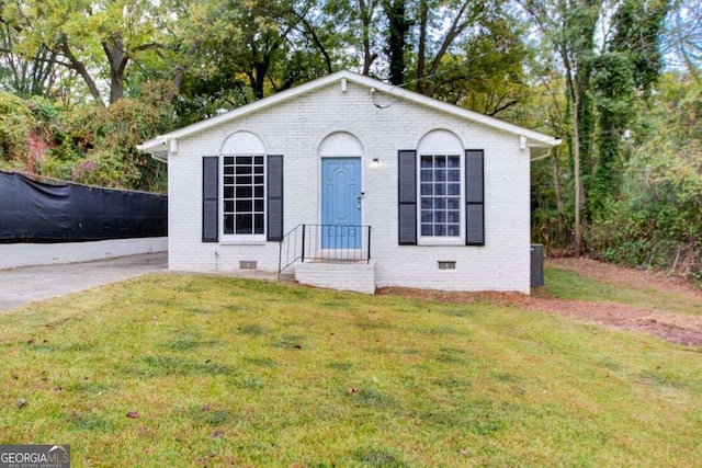 view of front of home with crawl space, a front yard, and brick siding