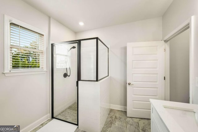 bathroom with recessed lighting, tiled shower, vanity, and baseboards