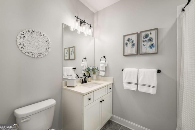 bathroom featuring vanity, toilet, and baseboards