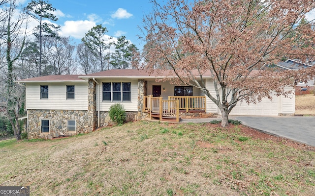 ranch-style home with a garage, covered porch, driveway, and a front lawn