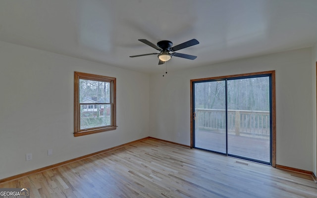 spare room featuring ceiling fan, light wood-style flooring, and baseboards